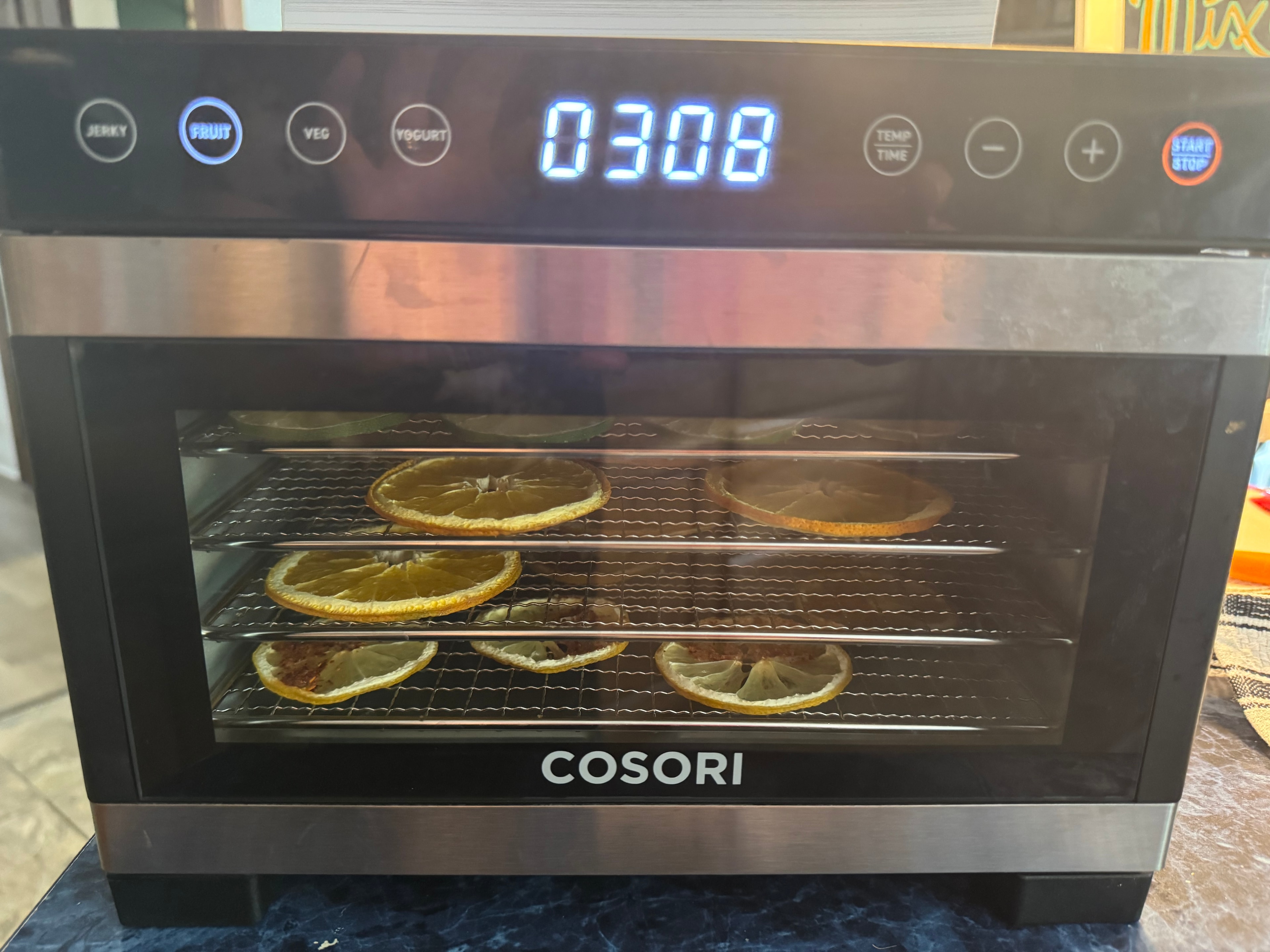 Cosori dehydrator running with citrus slices inside for cocktail garnish prep
