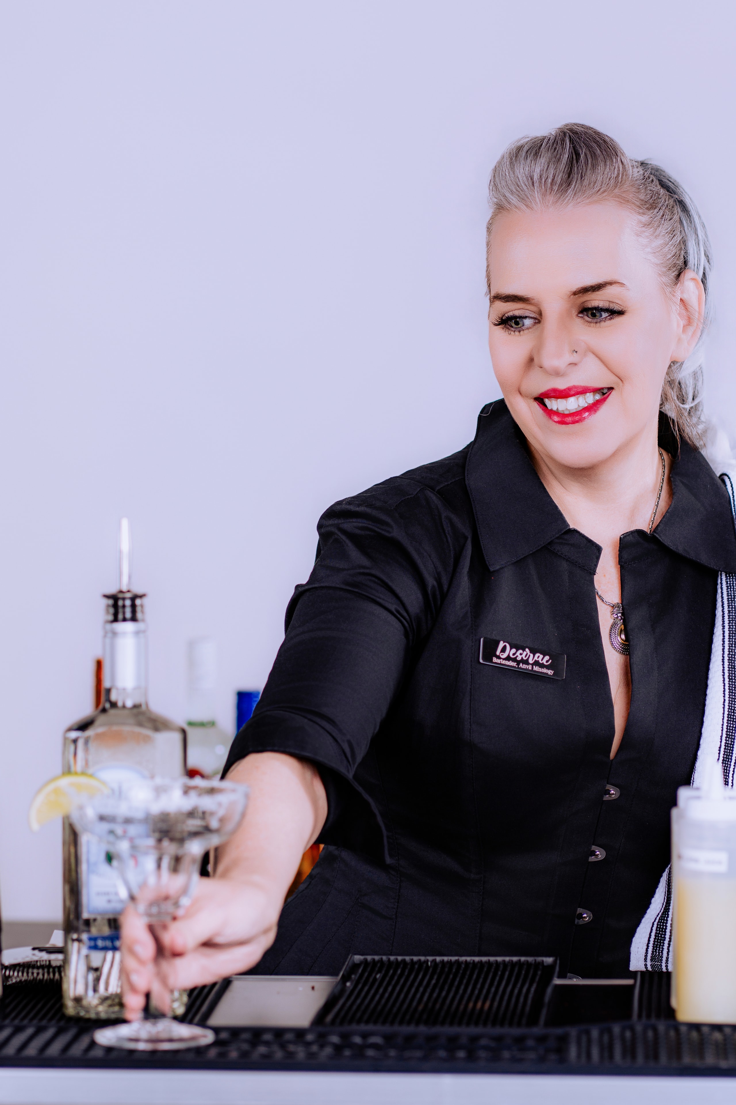 Desirae setting a margarita glass on the bar