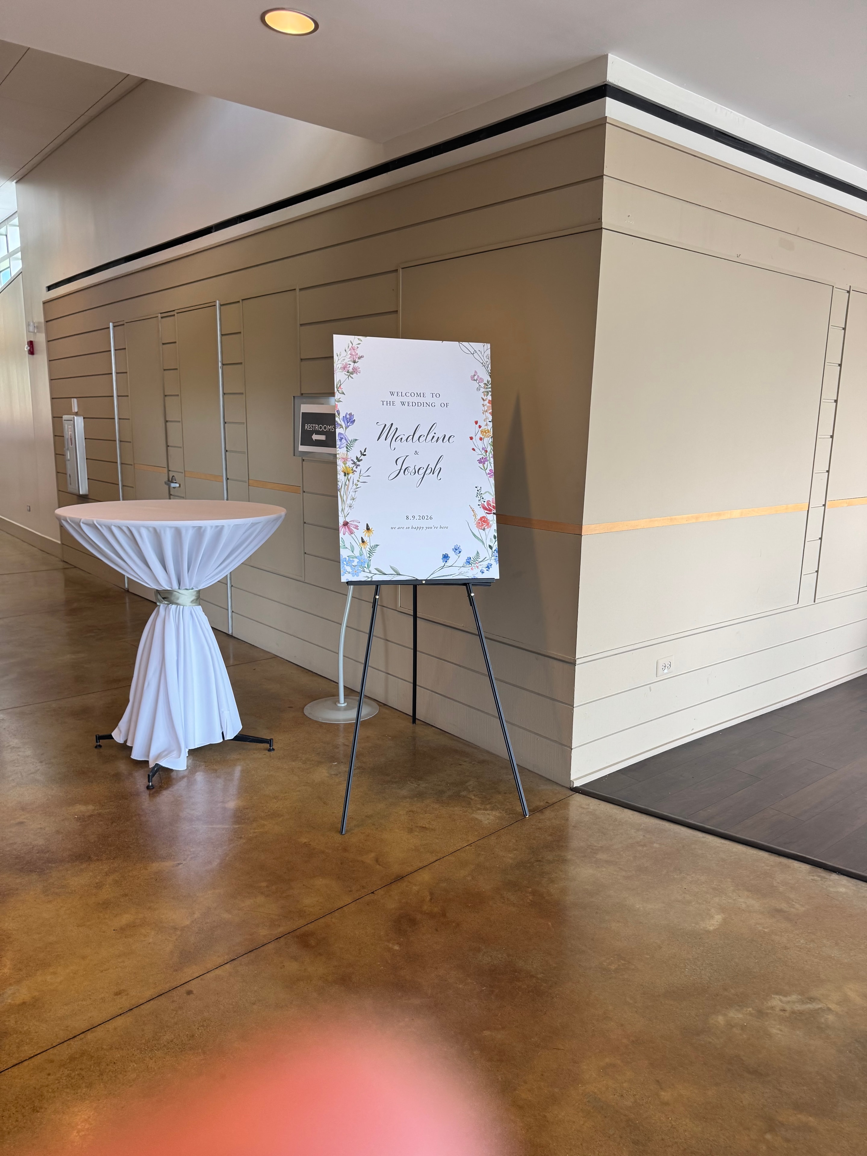 Welcome sign for the wedding of Madeline and Joseph with cocktail table in the foyer